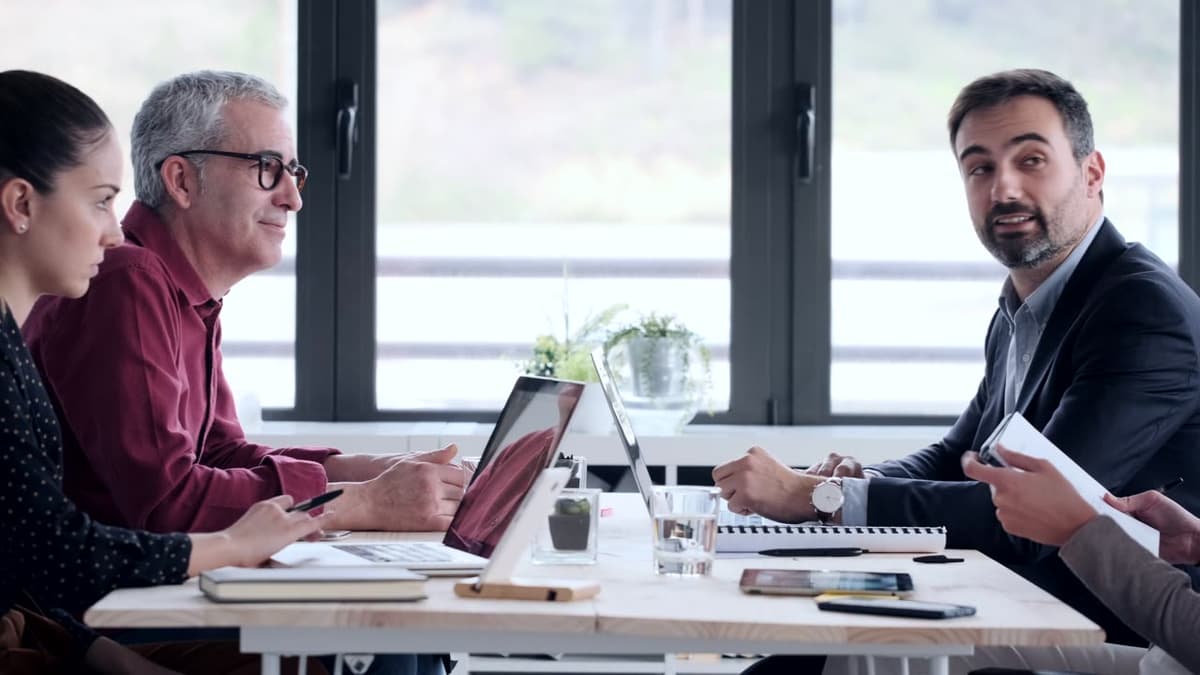 Two leaders in conversation by a window