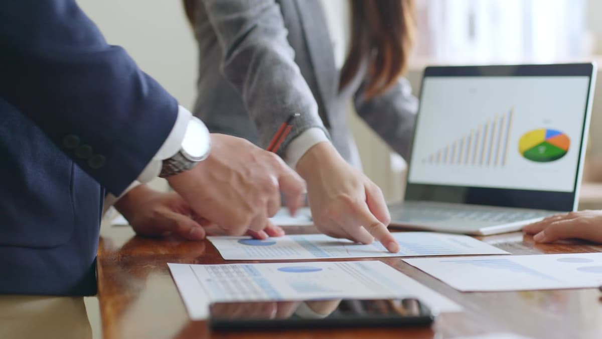 Hands pointing at charts on a printed report