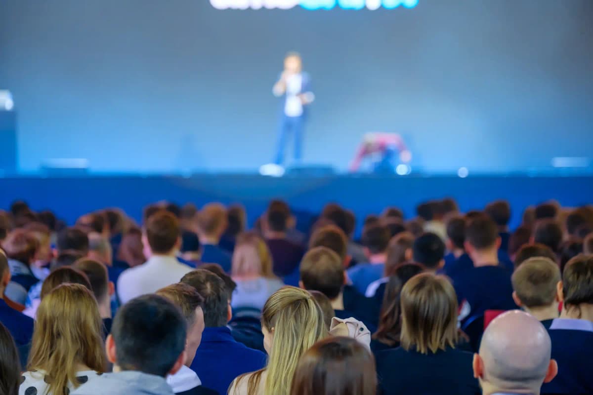 An audience listening to a speaker at a conference