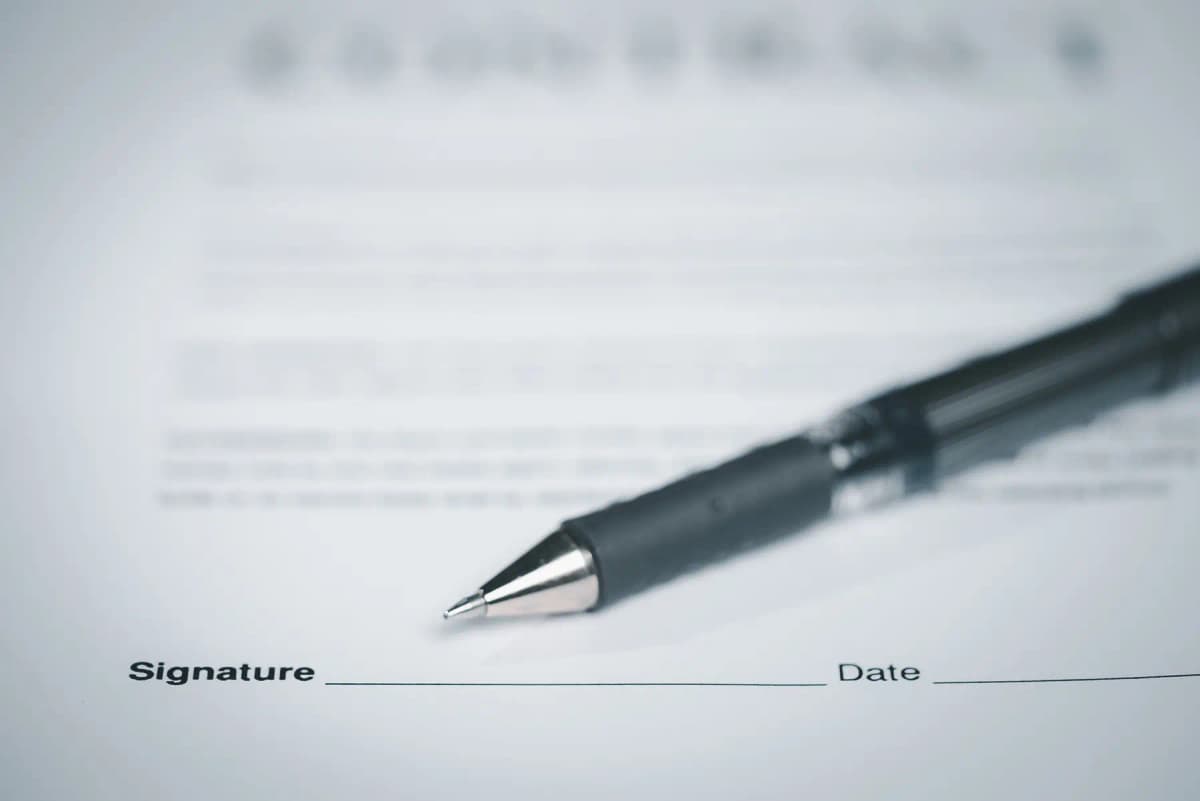 A pen resting on a contract ready for signature